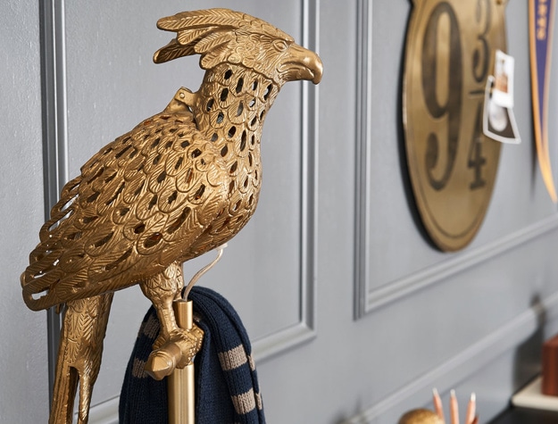 A floor lamp featuring a phoenix-shaped shade stands in a room.