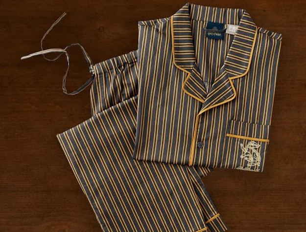 Pajamas inspired by Hufflepuff House from Harry Potter lay on a wooden backdrop.