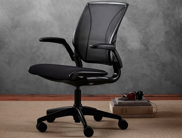 black office chair with stack of books and headphones