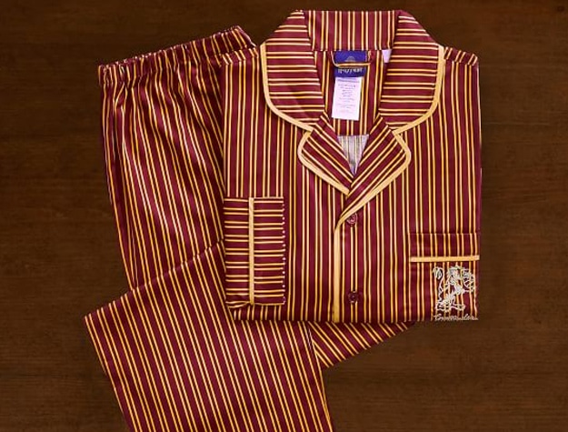 A pajama set inspired by Gryffindor House from Harry Potter rests on a wooden backdrop.