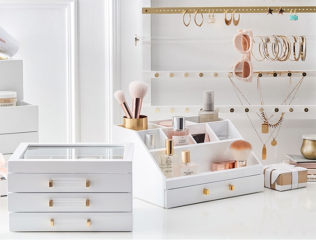 White drawer organizers with makeup and perfumes