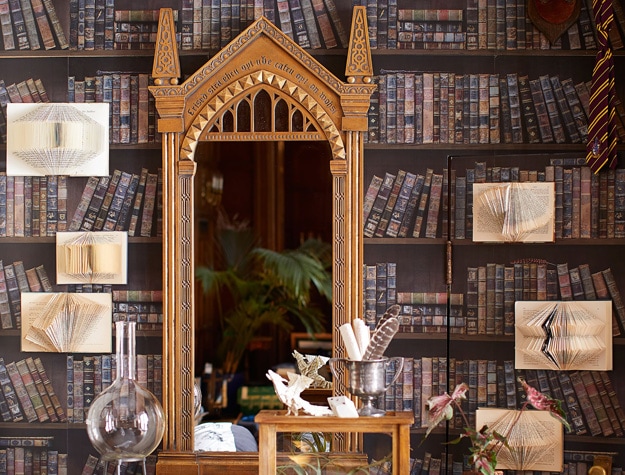 A mirror shaped like the Mirror of Erised from Harry Potter rests against a wall.