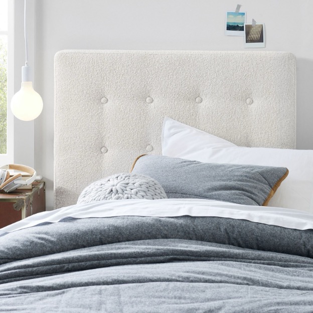 A white tufted no-nails headboard features a charging port for tech accessories.
