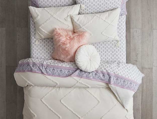 White, geometric duvet cover and shams with paisley patterned sheets.