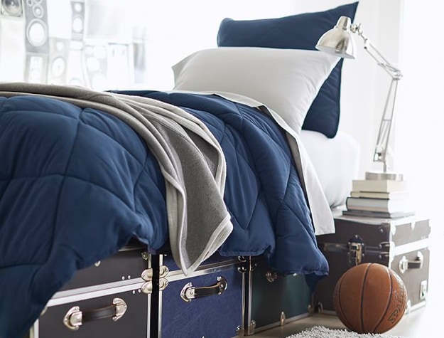 Assorted dorm trunks underneath bed