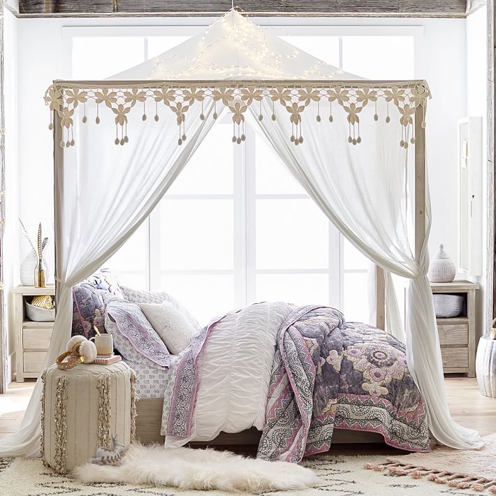 canopy bed in front of window