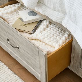Close-up of the top drawer interior filled with soft textiles.