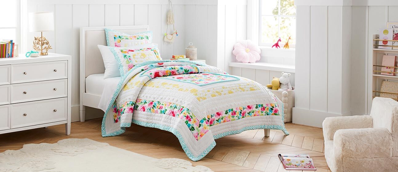 Bedroom with a brightly colored floral quilt