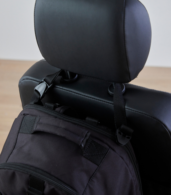 The fourth photo shows close up of a Pottery Barn Teen Gear-Up Adaptive Backpack in Black Solid print affixed the headrest of an assistive device.