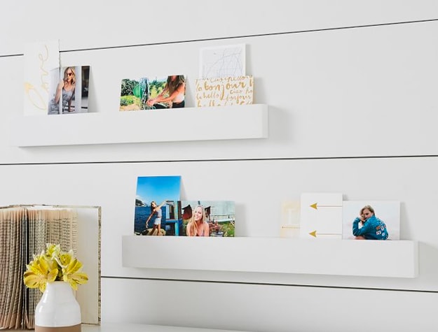 White photo rail on wall with pictures