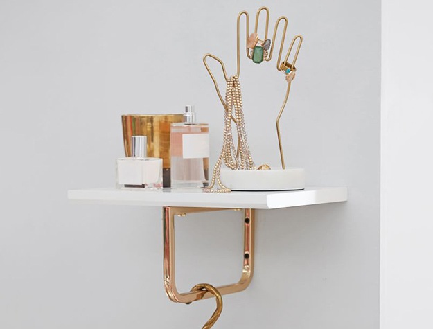 Marble gold hand jewelry holder on shelf