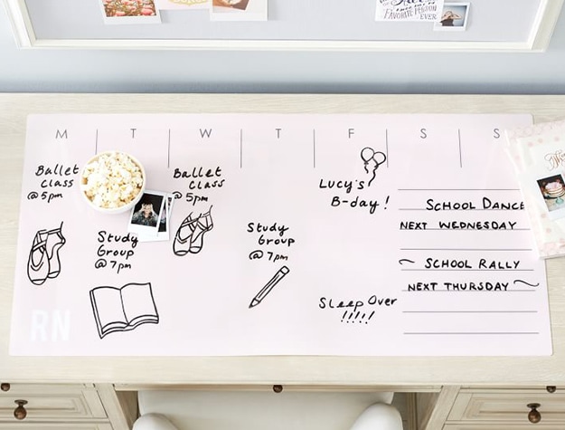 Dry-erase desk mat with scribbles and notes