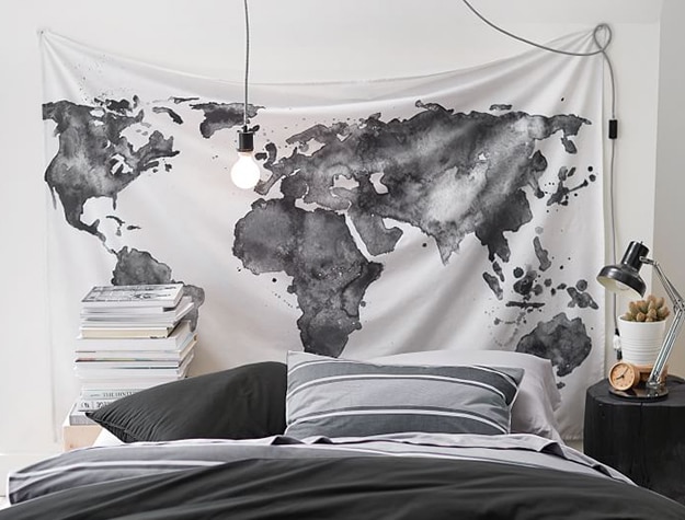 Black and white world map tapestry behind bed