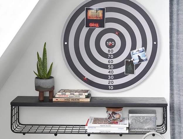 Black and white magnetic dart board above shelve