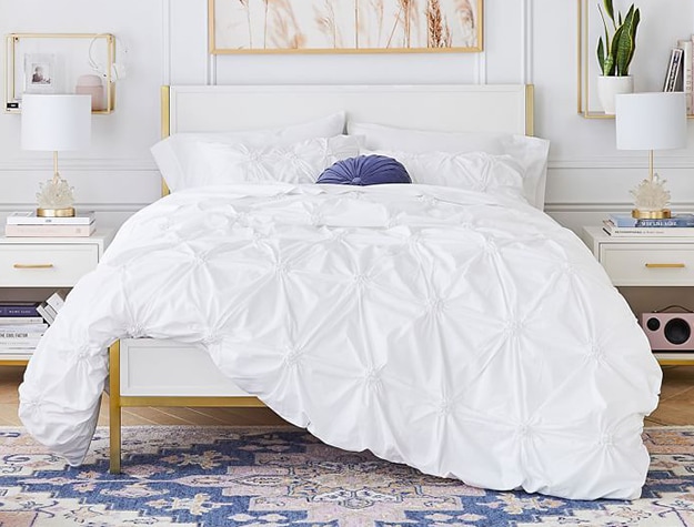 Ruched white comforter in bright white room