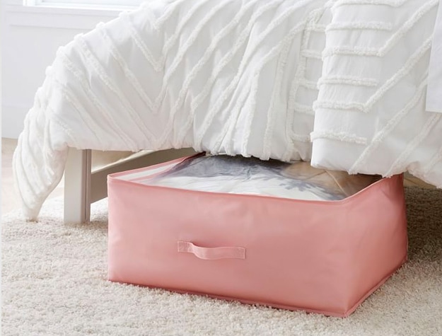 Pink RPET Stuff and Store Underbed bin underneath a bed with a white comforter.