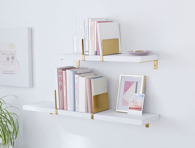 Two white and gold modern floating shelves.