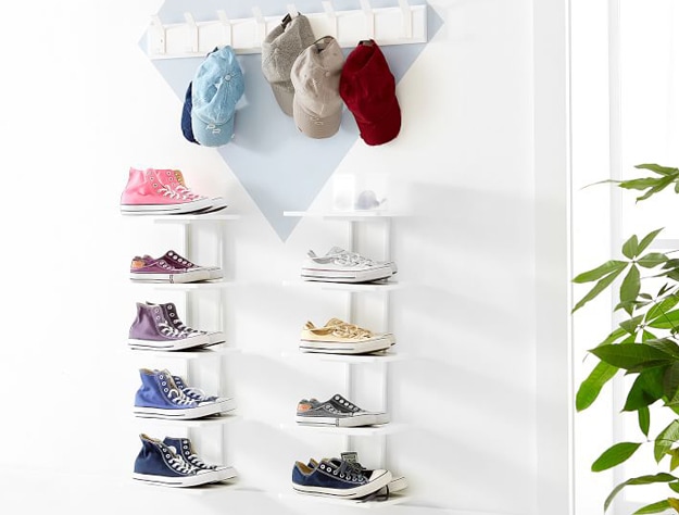 Sneaker collection on white floating shelves.