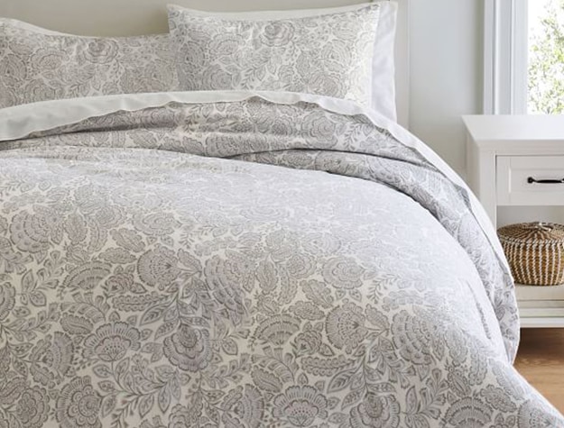 A floral silver-patterned bedspread brightens up a room.