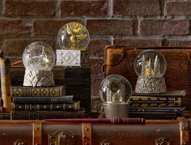 Harry Potter snow globes rest on a leather travel trunk.
