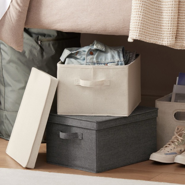 Stackable underbed storage bins shown under a dorm bed