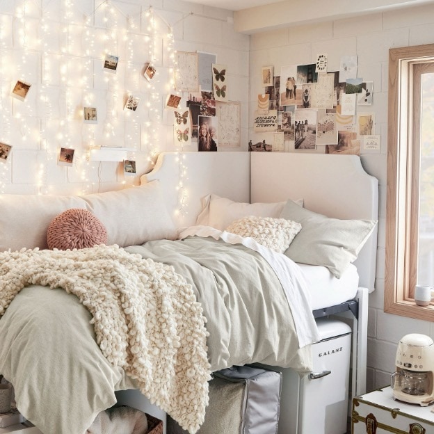 String lights and a photo wall are shown as key decor features in this girl dorm room.