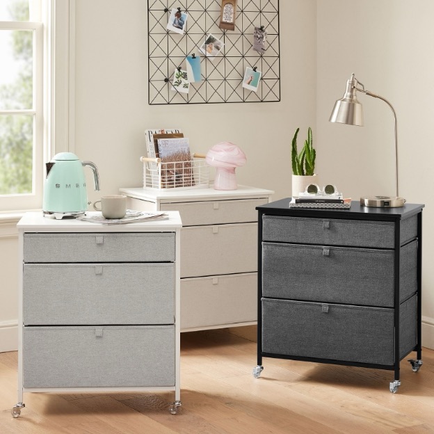 A trio of 3-drawer rolling carts sit in a dorm room, offering storage for extra clothes, tech accessories, and books.