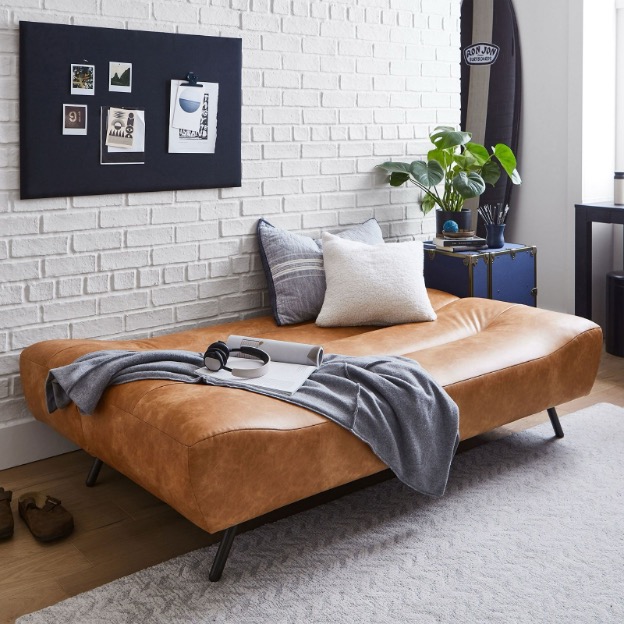 A faux leather sleeper sofa is pulled out into its bed function.