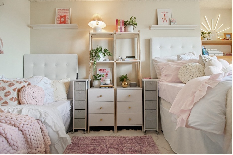 Narrow bookcases shown in a dorm room provide vertical storage for decor, plants, and lighting.