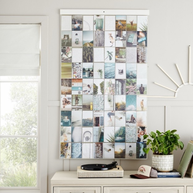 Photos displayed in a clear photo holder hanging on the wall of a bedroom 