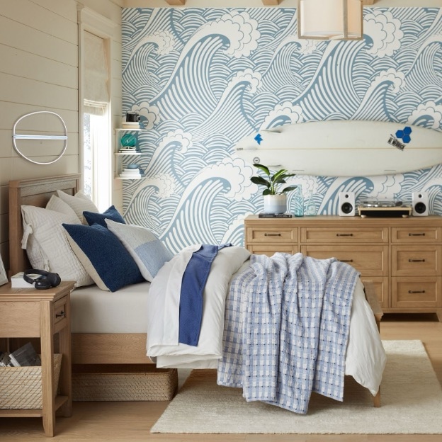 A crashing wave-icon wallpaper sets the tone in this coastal-prep boy’s bedroom