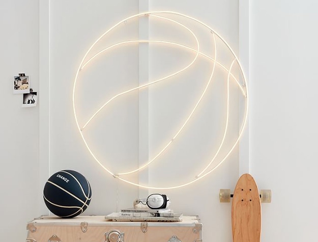 Neon basketball light hanging on wall.