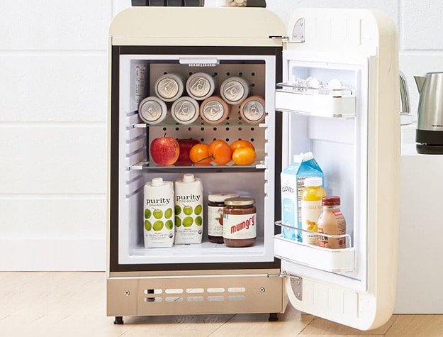 Smeg mini fridge stocked with food.