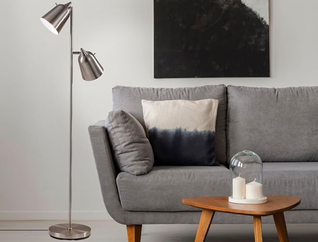 Dual Spotlight Floor Lamp next to gray sofa in a living room.