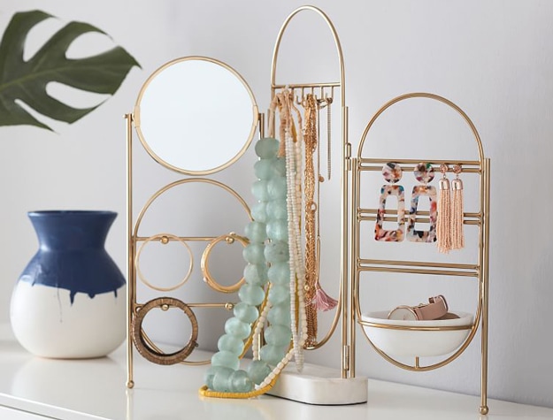 Marble and gold jewelry display stands with necklaces and earrings