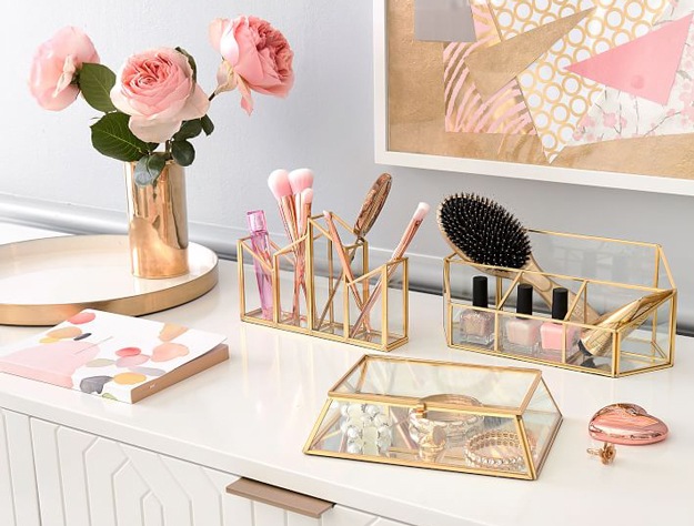 Gold and glass jewelry box and makeup holders on armoire