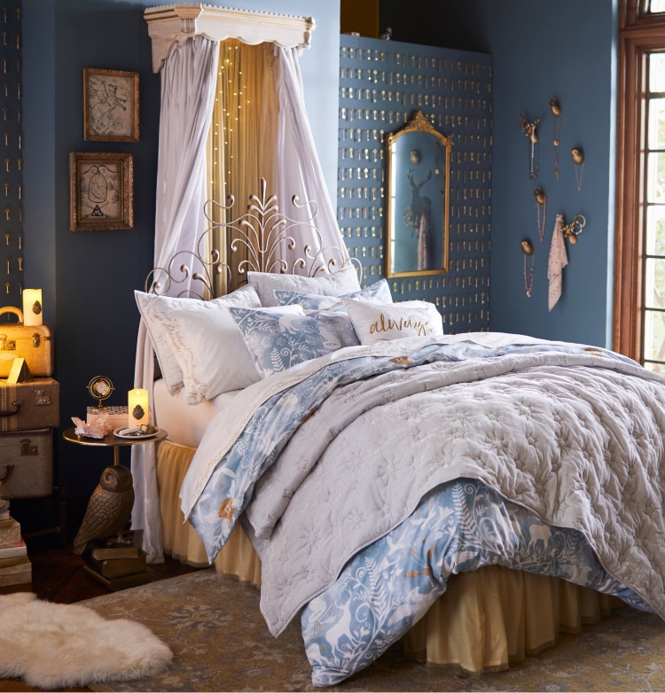 Harry Potter sample designed room. Shows a blue with gold themed accent bedroom with a bed with plush bedding, matching the color palette of the room. The gold accents around the room include Harry Potter themed items such as teh Golden Snitch, and a gold foiled image of a stag, which is Harry's patronus spell's form.