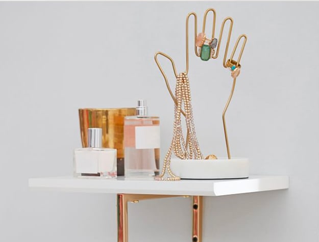 Hand-shaped jewelry holder on shelf Hand-shaped jewelry holder on shelf