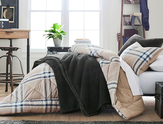Black sherpa throw on bed with plaid comforter Black sherpa throw on bed with plaid comforter