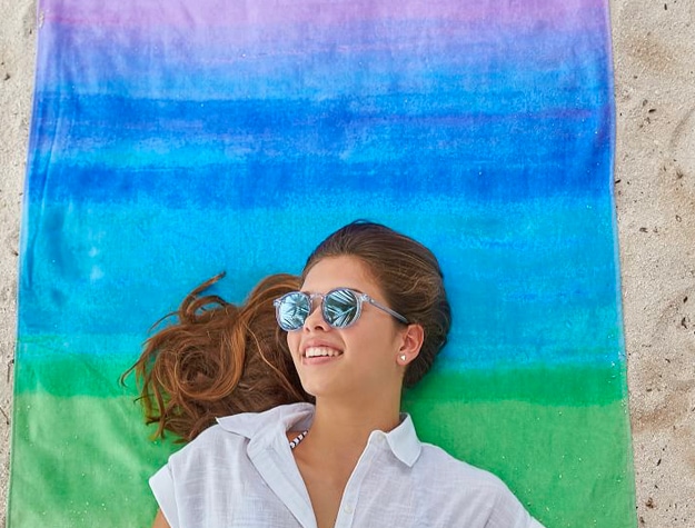 Teen girl smiling on beach towel Teen girl smiling on beach towel