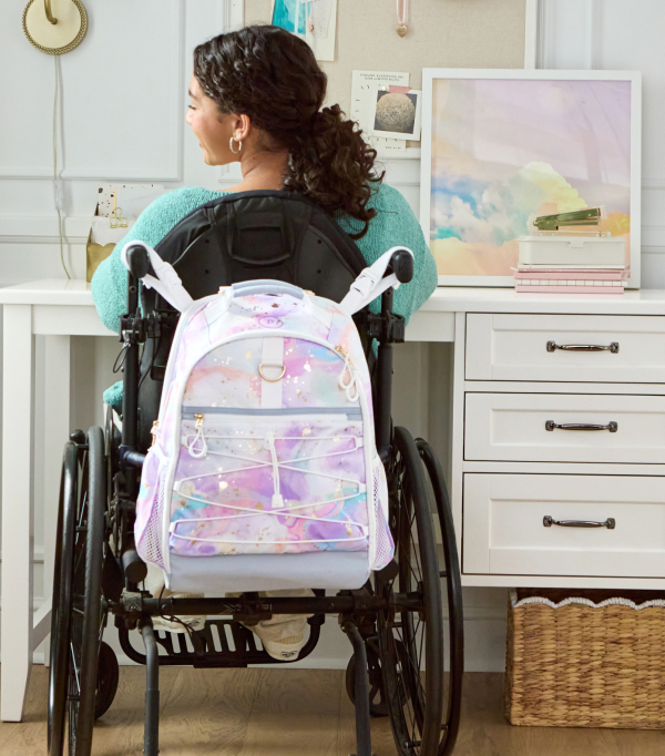 The fourth photo shows close up of a Pottery Barn Teen Gear-Up Adaptive Backpack in Black Solid print affixed the headrest of an assistive device.