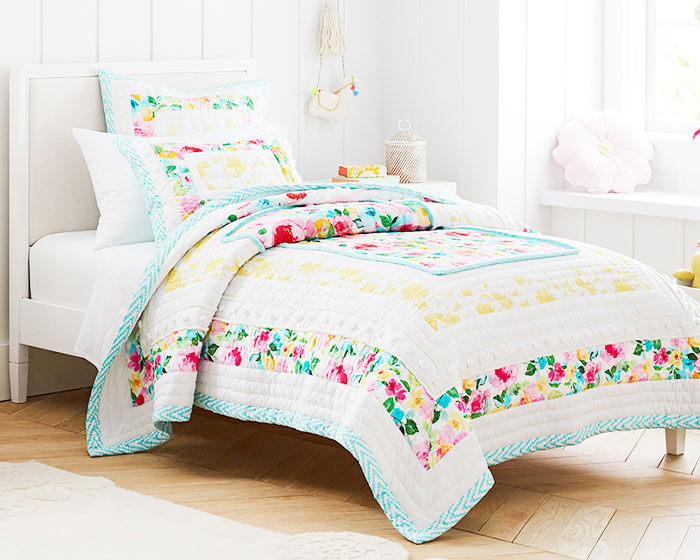 Bedroom with a brightly colored floral quilt